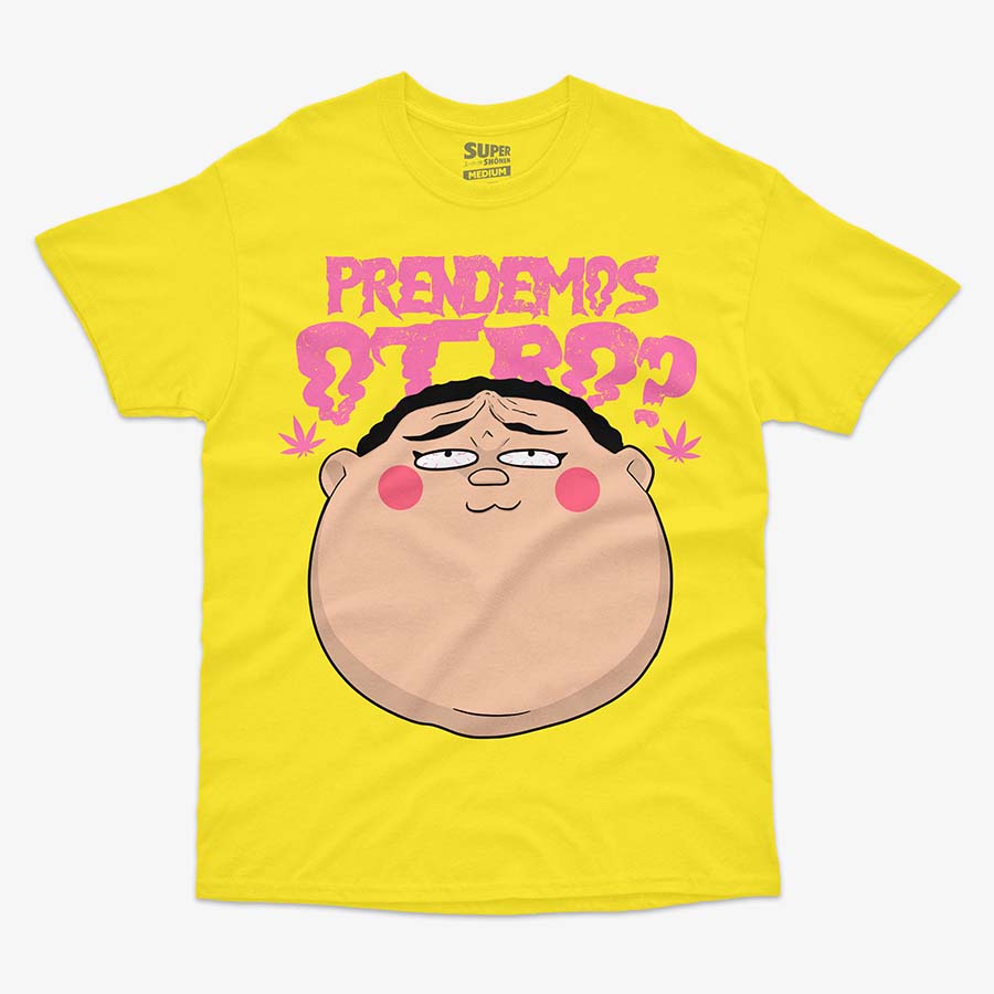 Polera amarilla de Dotto! Koni-chan. Diseno central de la cabeza de Koni-chan con rubor en las mejillas, debajo del texto rosa que dice 'PRENDEMOS OTRO?' en letras gruesas y irregulares. A los costados del texto, se ven dos hojas de marihuana en color rosa.