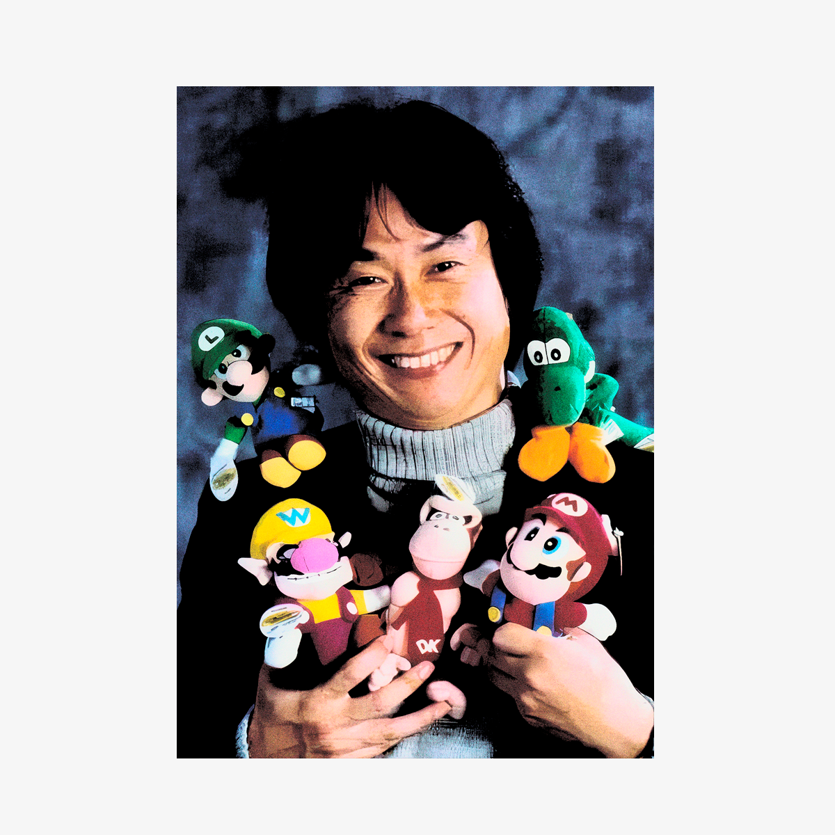 Retrato del diseñador de videojuegos Shigeru Miyamoto de Nintendo, sonriendo y sosteniendo peluches de Mario, Luigi, Yoshi, Wario y Donkey Kong en una fotografía icónica