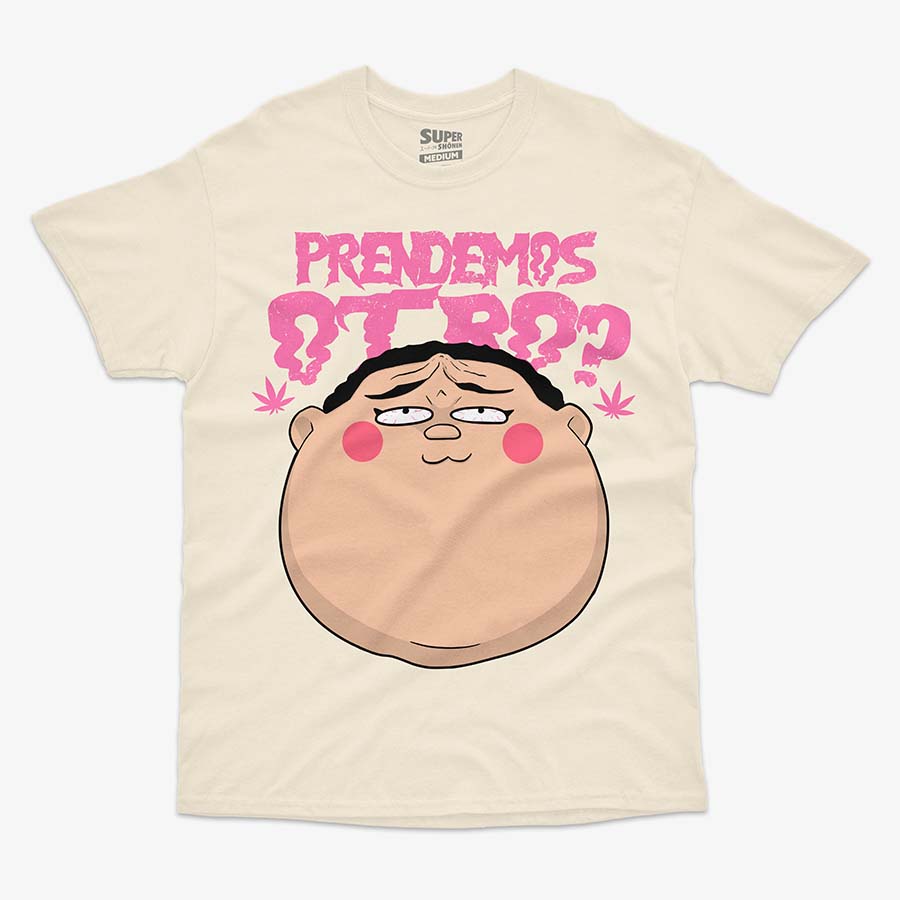 Polera color arena de Dotto! Koni-chan. Diseno central de la cabeza de Koni-chan con rubor en las mejillas, debajo del texto rosa que dice 'PRENDEMOS OTRO?' en letras gruesas y irregulares. A los costados del texto, se ven dos hojas de marihuana en color rosa